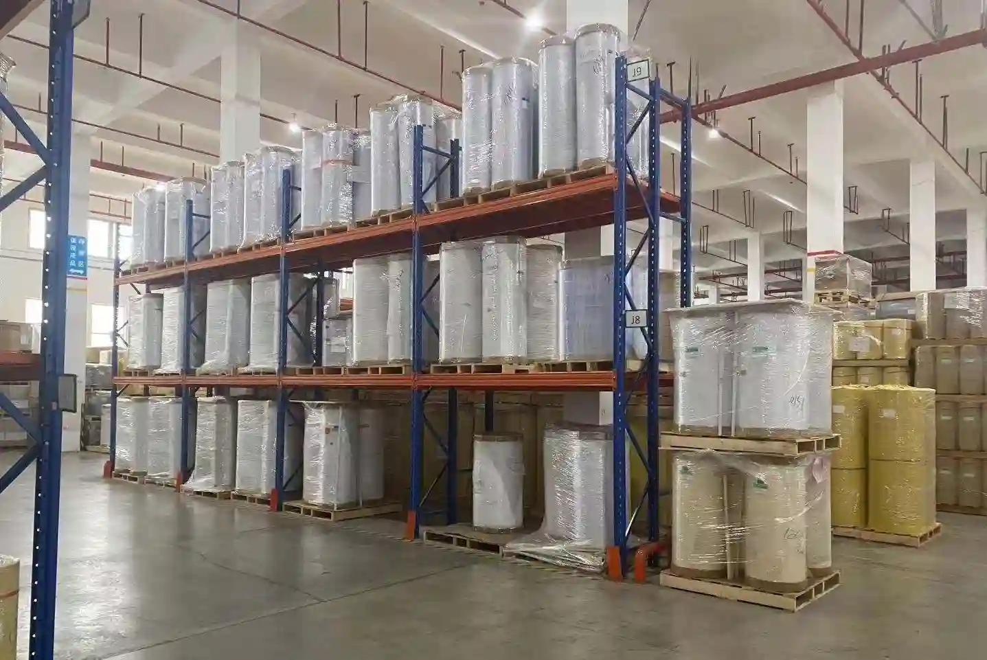Interior of Tradsark film warehouse with shelves of PE, PET, and BOPP metallized film rolls